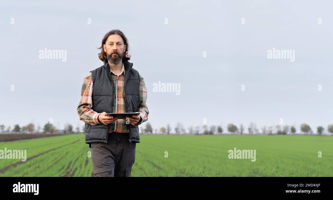 Agriculteur avec une tablette numérique sur un terrain. Agriculture intelligente et agriculture numérique Banque D'Images