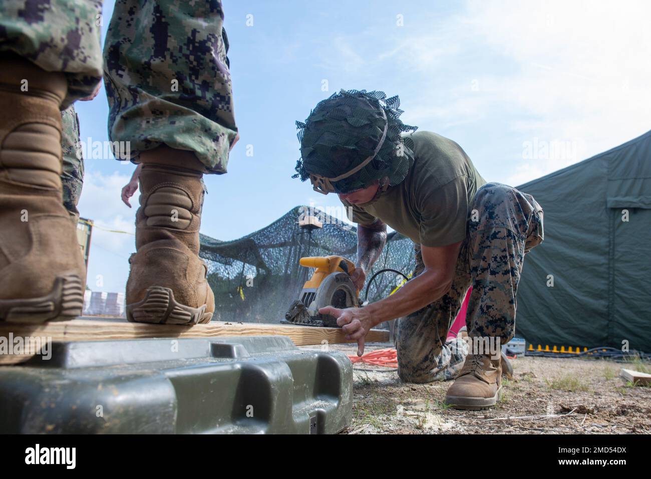 CAMP SHELBY, divers (13 juillet 2022) le Soldat 1st Class Eliseo Garcia de Los Angeles affecté au Marine Wing support Squadron (MWSS) 273 coupe le bois d'œuvre à l'appui du NMCB (Naval Mobile Construction Battalion) 1 en préparation de projets de construction pendant l'opération Turning point, également connue sous le nom d'exercice d'entraînement sur le terrain. Operation Turning point est un exercice 24 heures sur 24 qui se concentre sur la construction de bases avancées tout en maintenant la maîtrise des tactiques et de la capacité de survie. NMCB 1 est domiciliaire à partir de Gulfport, Mils Ils mènent un plan de formation intense à homeport pour étendre leur système Banque D'Images