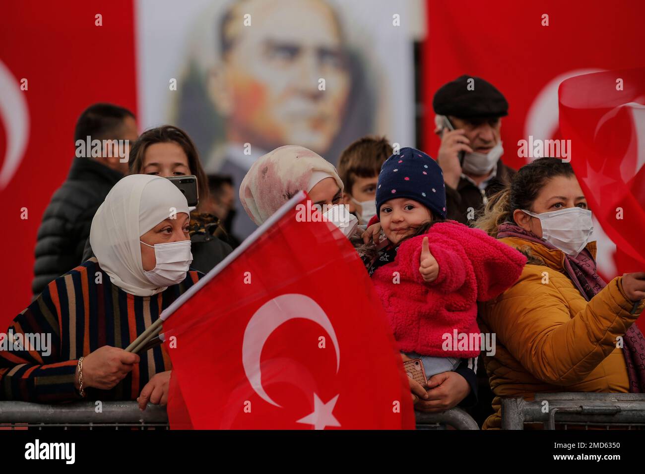 People wave Turkish flags as they watch a parade during the celebration of Turkey's Republic Day