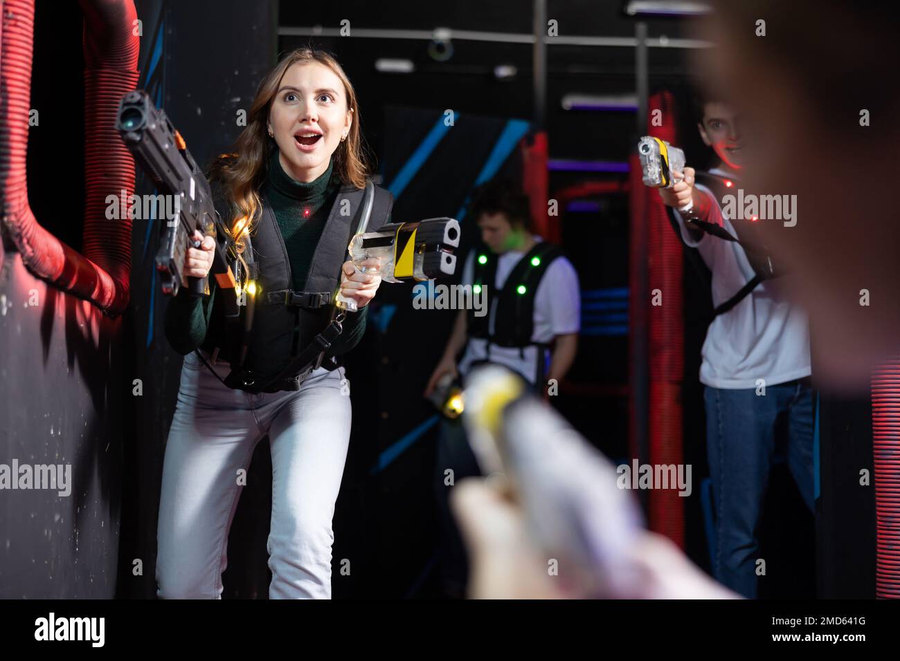 Jeune femme s'amusant à jouer lasertag dans l'arène Banque D'Images