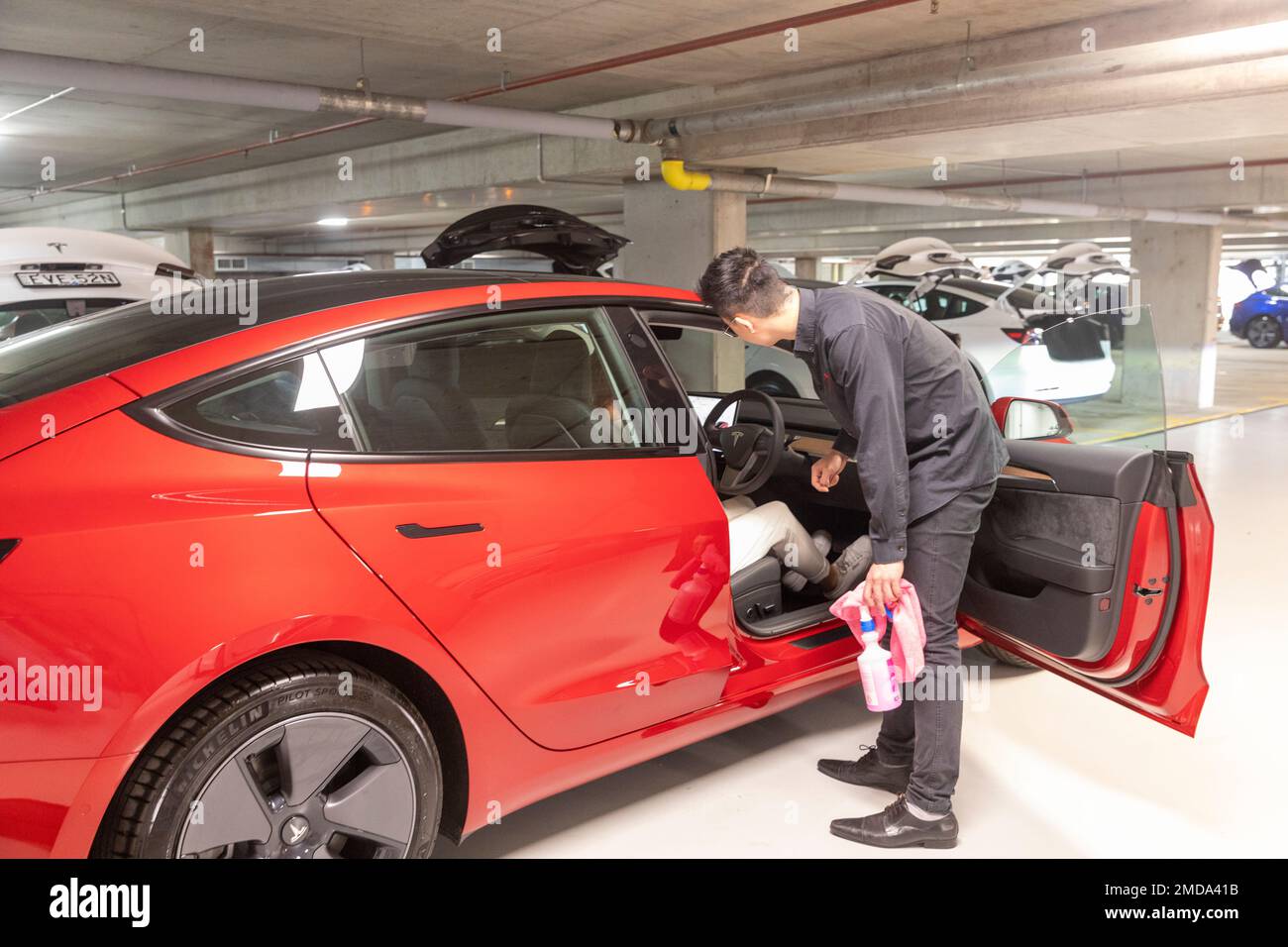 Tesla modèle 3 Lady Woman collecte sa toute nouvelle voiture de Tesla et reçoit des instructions sur le EV par l'employé de Tesla lors de la remise de véhicule, en Australie Banque D'Images