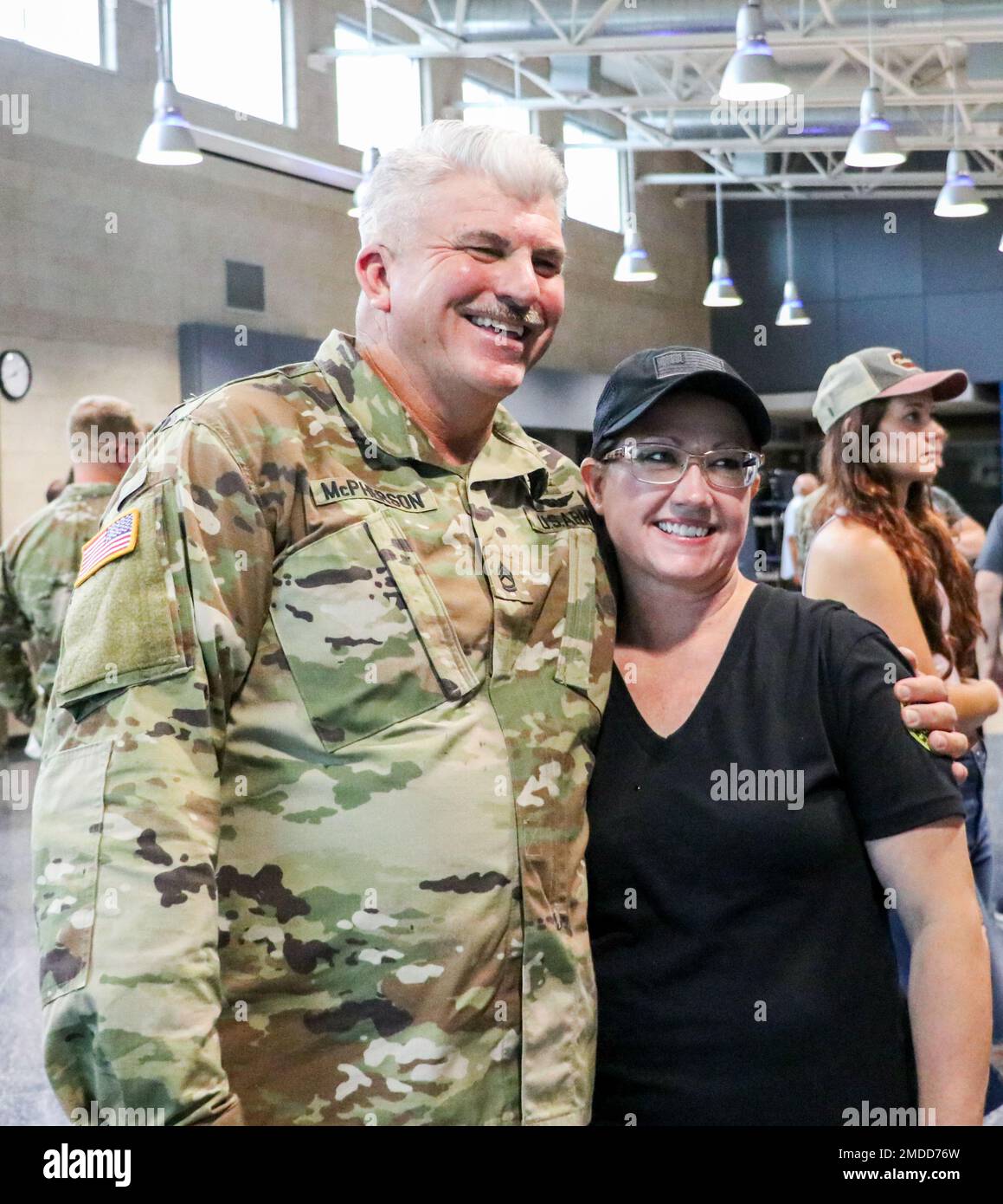 Un soldat de la Garde nationale de l'armée de l'Iowa affecté à la compagnie médicale 209th (soutien de zone) prend une photo avec un être cher après la fin d'une cérémonie d'envoi à l'école secondaire d'Amana de Clear Creek à Tiffin, Iowa, sur 16 juillet 2022. Les hauts dirigeants, la famille et les amis se sont réunis dans l'auditorium pour rendre hommage aux 80 soldats qui se mobilisent en Pologne pour appuyer l'opération Atlantique Solve. Ils fourniront un soutien aux services de santé des hôpitaux de terrain dans le cadre de la mission de présence avancée renforcée de l’OTAN, qui permet aux États-Unis d’offrir une dissuasion à leurs adversaires tout en soutenant nos partenaires de l’OTAN. Banque D'Images