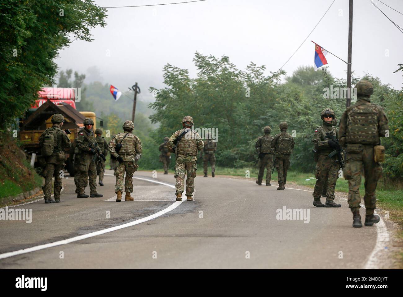 Polish soldiers, part of the peacekeeping mission in Kosovo KFOR, pass through barricades as they patrol near the northern Kosovo border crossing of Jarinje, along the Kosovo-Serbia border, Saturday, Oct. 2, 2021. A NATO-led peacekeeping mission in Kosovo took over the area near two Kosovo-Serbia border crossings following the deal reached by the two countries to deescalate tensions triggered by a dispute over vehicle license plates. (AP Photo/Visar Kryeziu) Banque D'Images