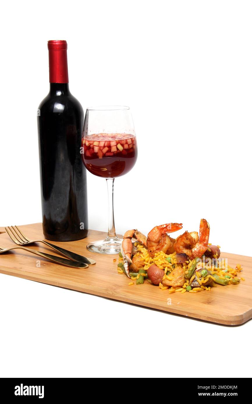 Riz traditionnel paella de Valence Espagne, fait avec des coquillages safran, des crevettes et des légumes servis sur une planche de bois accompagnée de vin rouge Banque D'Images