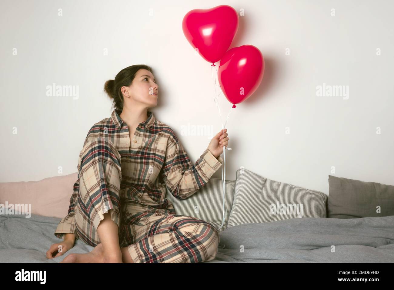 Femme dépressive avec ballon gonflable le jour de la Saint-Valentin. Vue avant. Banque D'Images