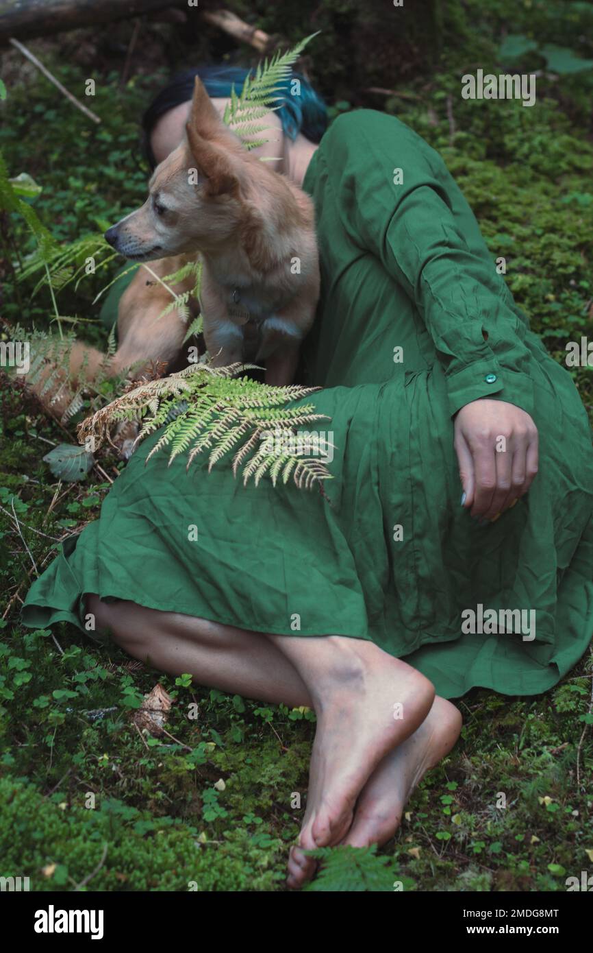 Gros plan femme avec chien couché sur de la mousse verte dans la forêt concept photo Banque D'Images
