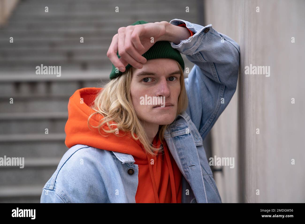 Portrait urbain de style hippster chic et tendance avec une longue coiffure posant à l'extérieur Banque D'Images