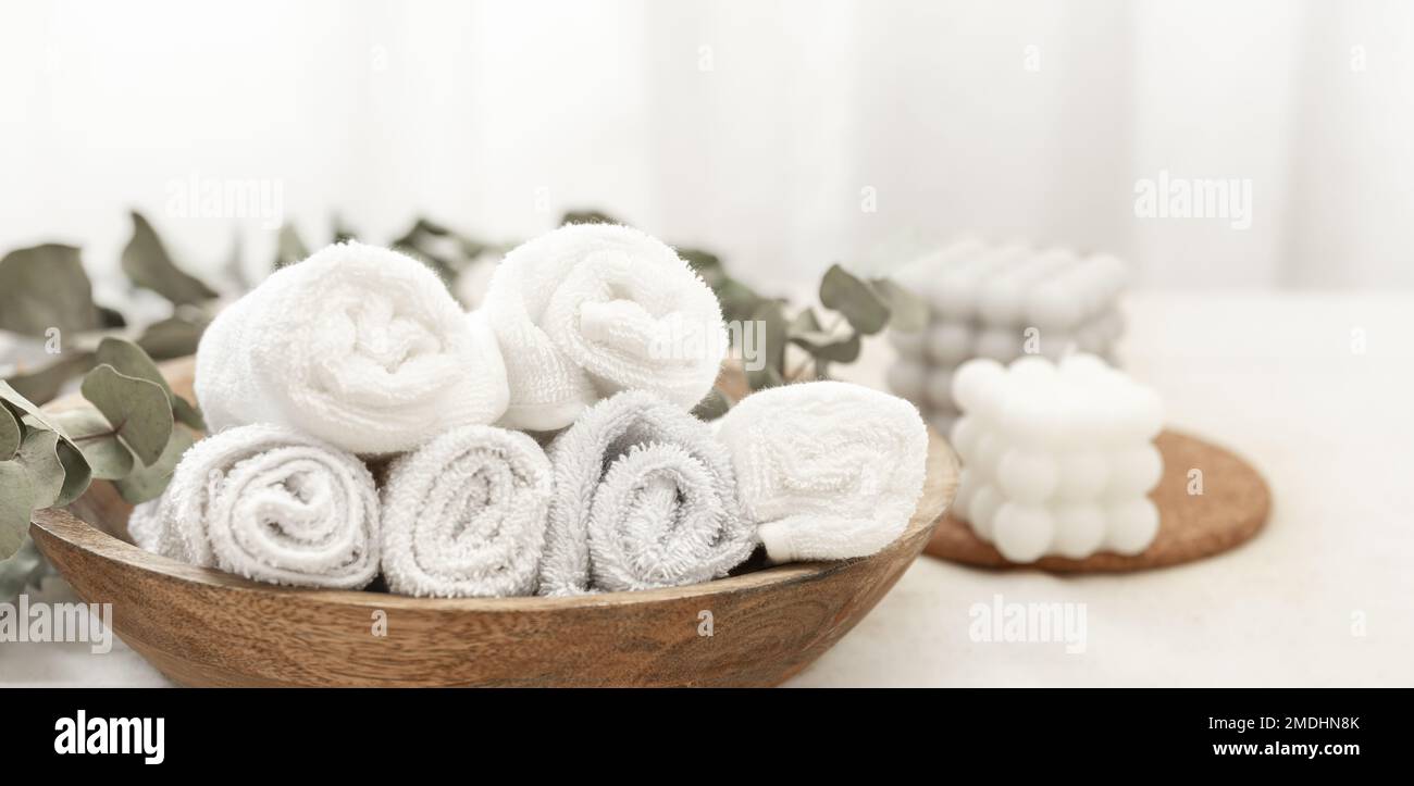 Composition spa avec serviettes blanches dans une assiette en bois. Banque D'Images