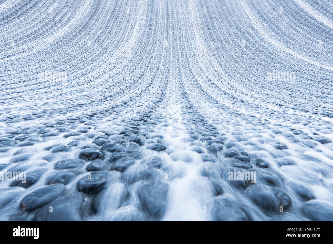 Petite chute d'eau et un ruisseau d'eau dans un jardin ou un parc. Résumé fond d'eau d'été. Ruisseau artificiel dans le jardin d'été. Banque D'Images