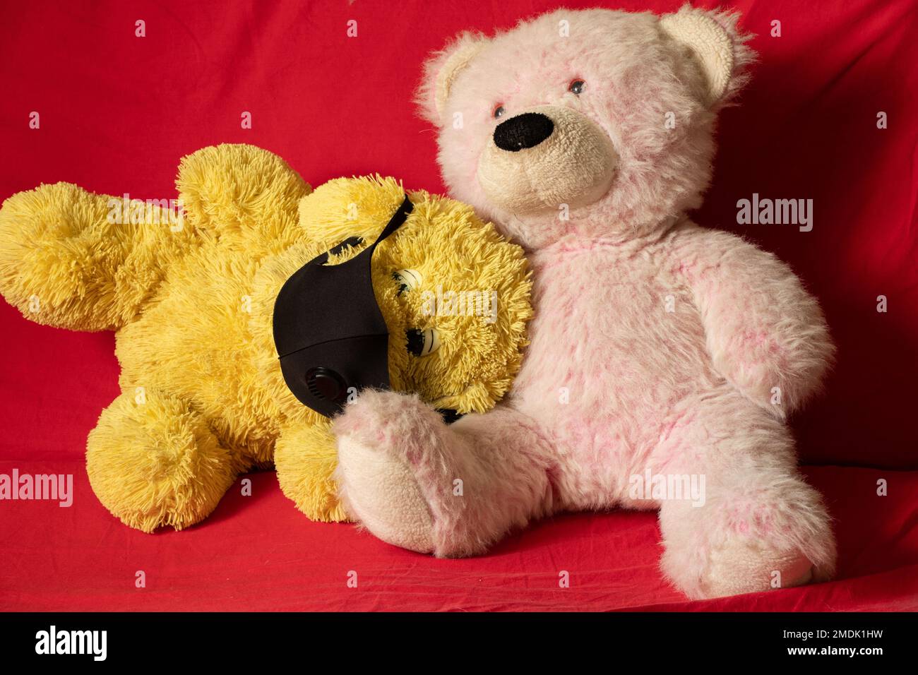 les jouets doux en peluche des enfants dans le masque médical se trouvent sur le canapé rouge, les soins de santé et la médecine, la morbidité des enfants Banque D'Images