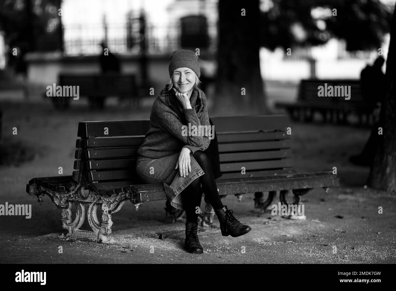 Une femme assise sur un banc de parc. Photo en noir et blanc. Banque D'Images