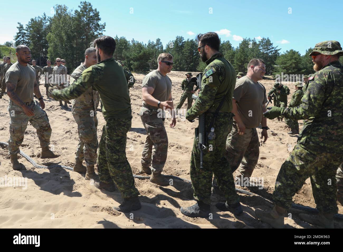 ÉTATS-UNIS Soldats affectés à Alpha Battery, 3rd Bataillon, 29th Régiment d'artillerie de campagne, 3rd équipe de combat de la brigade blindée, 4th Division d'infanterie, et les soldats canadiens de l'OTAN en présence avancée se secouent la main après un tir de compétition de guerre dans les champs du site d'opération avancée Adazi, Lettonie, 25 juillet 2022. L'ABCT de 3/4 est parmi les autres unités assignées à la Division d'infanterie de 1st, travaillant fièrement aux côtés des alliés de l'OTAN et des partenaires de sécurité régionaux pour fournir des forces crédibles au combat au V corps, le corps déployé avancé de l'Amérique en Europe. Banque D'Images