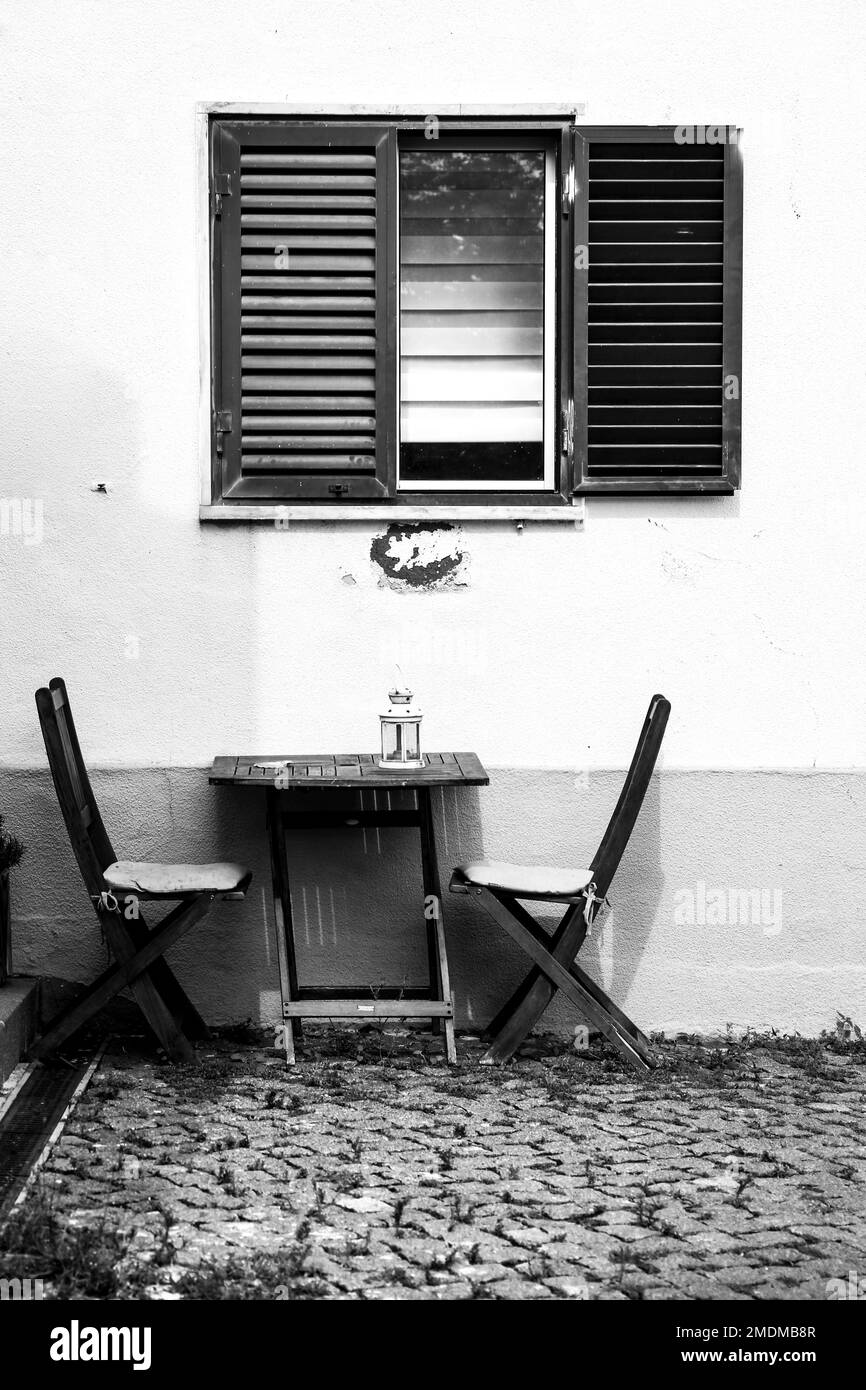 Façade typique de Lisbonne avec fenêtre ouverte et table et chaises en bois Banque D'Images