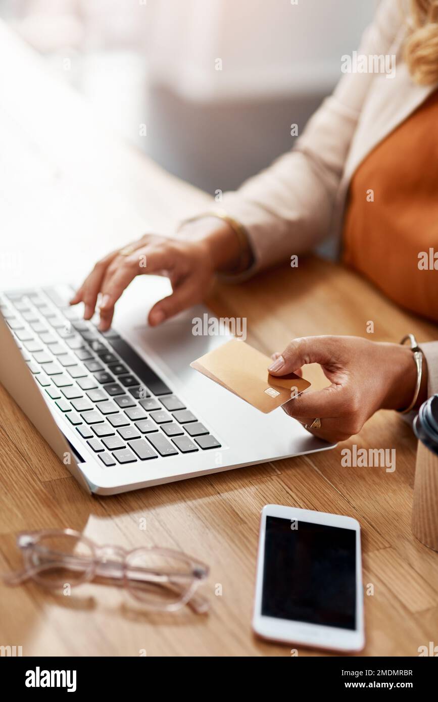 La cuisson en ligne est un moyen sûr et facile d'y aller. une femme d'affaires méconnaissable utilisant un ordinateur portable et une carte de crédit pour acheter en ligne dans son bureau. Banque D'Images