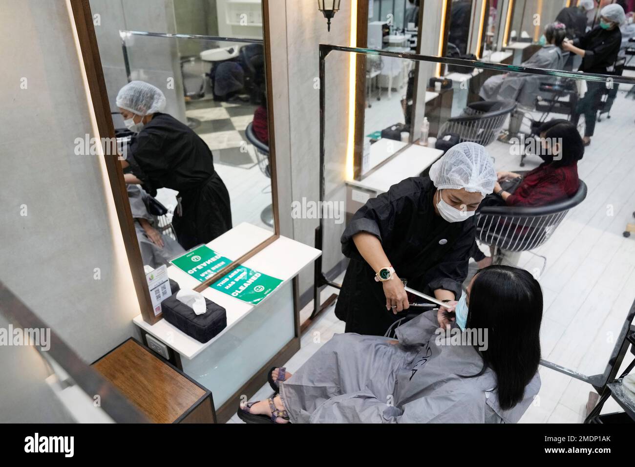 A barber cuts a customer's hair during the opening at the Paragon