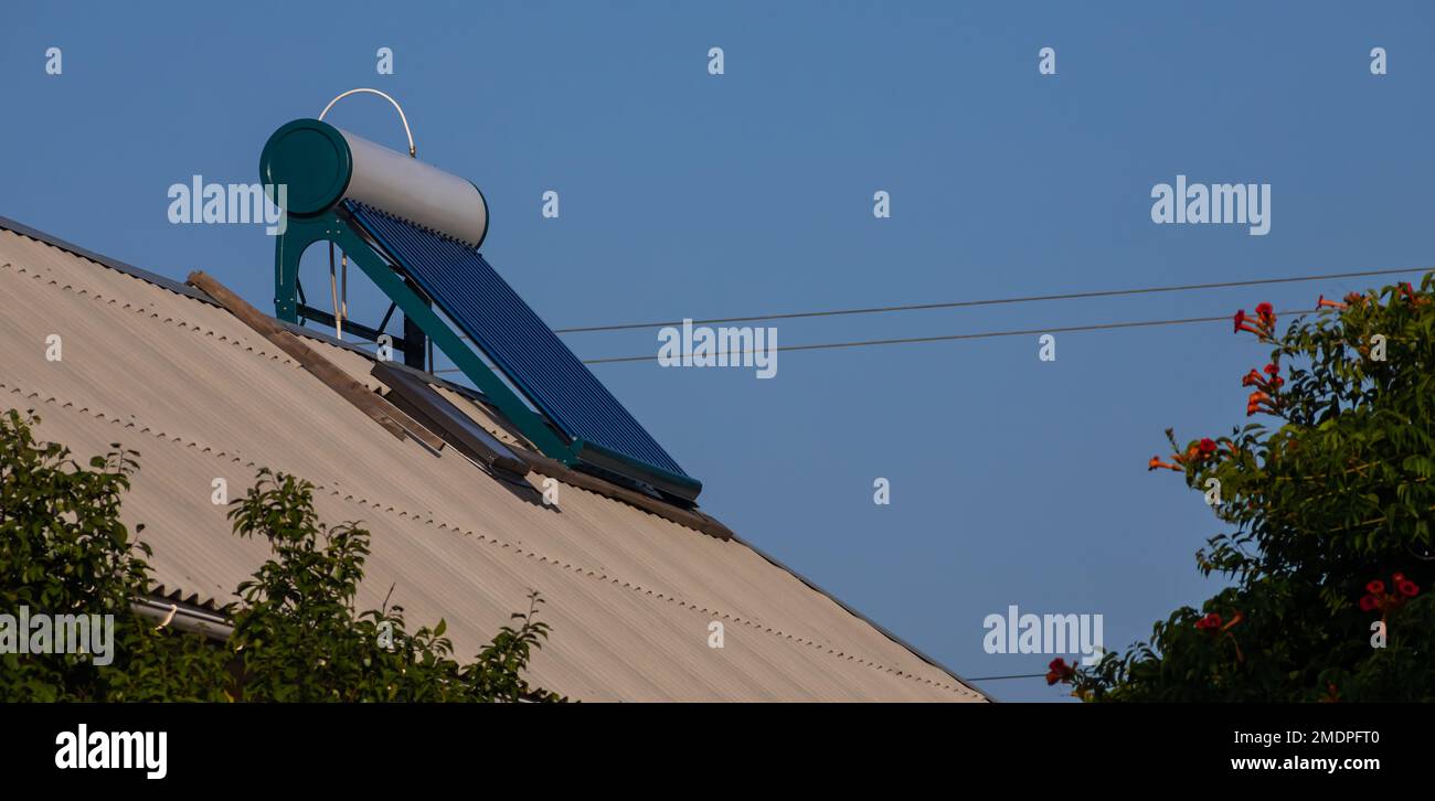 Chauffe-eau solaire sur le toit, beau fond de ciel bleu. Banque D'Images