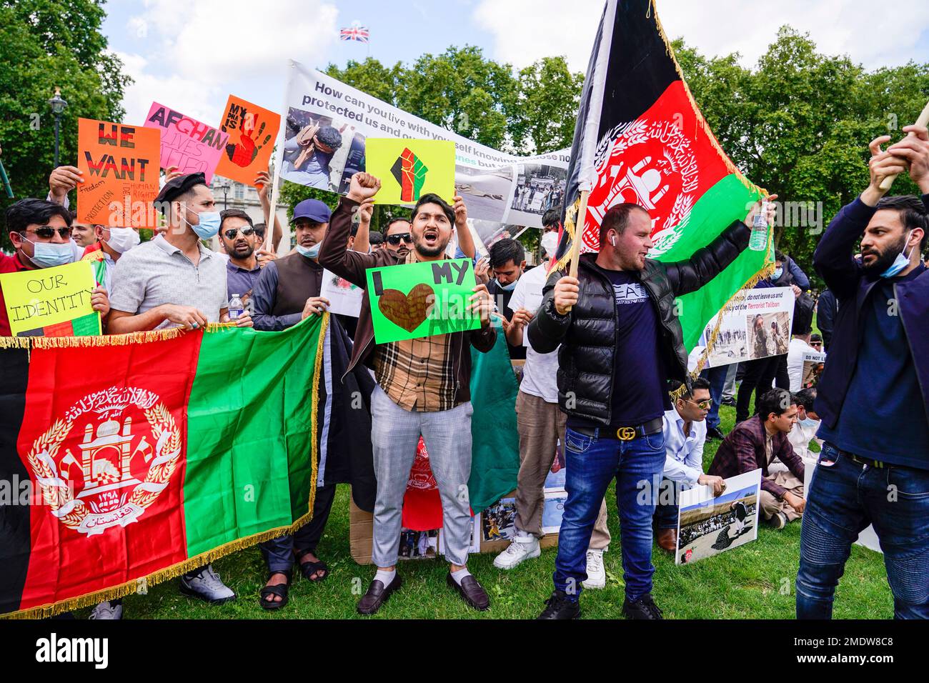Demonstrators hold Afghanistan flags, during a protest in Parliament Square, London, Wednesday, Aug. 18, 2021. Britain’s government says it plans to take in 5,000 Afghan refugees this year, especially women and children, in response to the Taliban's seizure of power. Officials provided details about the resettlement program on Wednesday as lawmakers held a heated emergency debate on developments in Afghanistan. (AP Photo/Alberto Pezzali) Banque D'Images