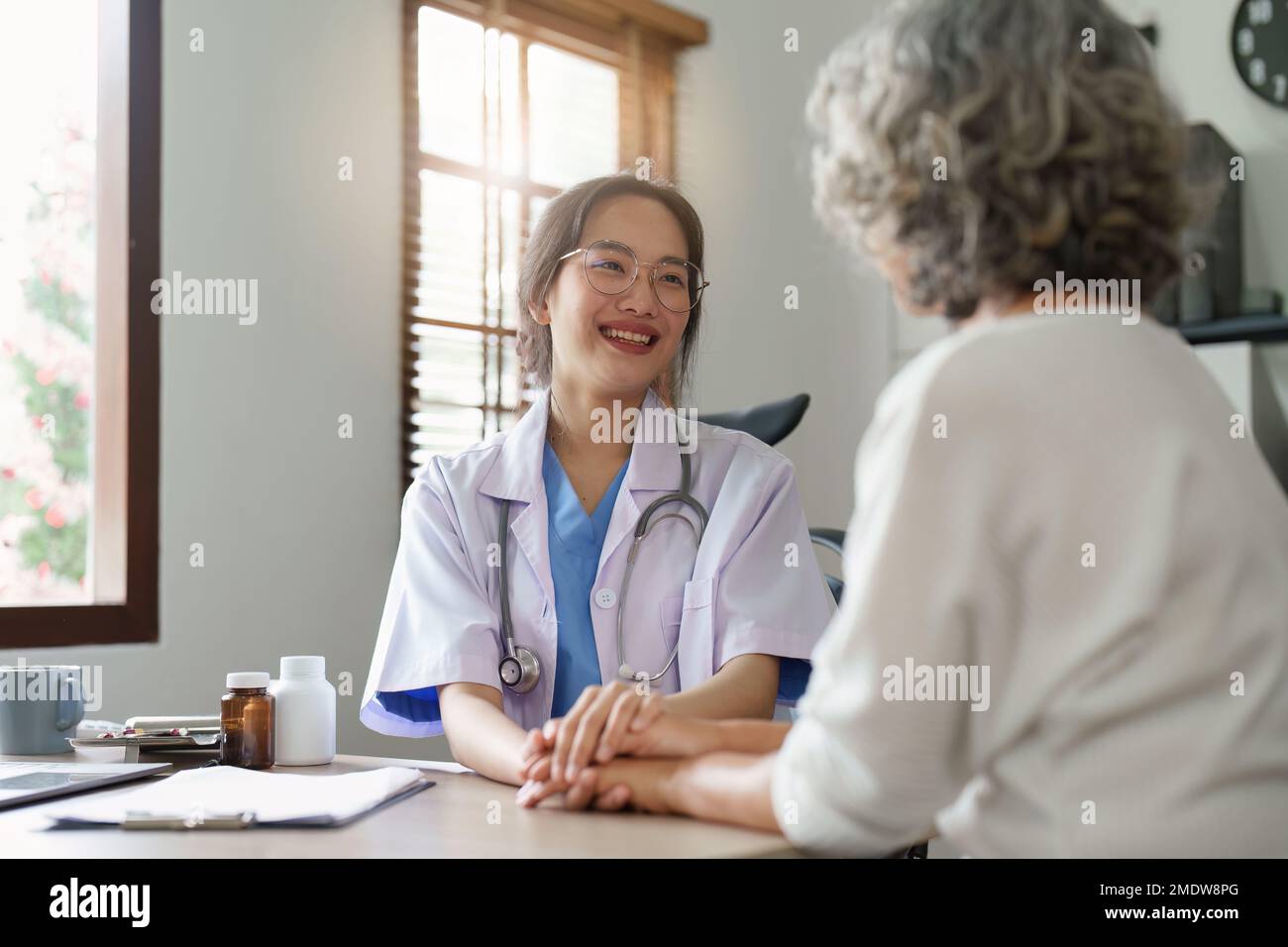 Médecin parlant avec une femme asiatique âgée. Femme médecin de soins primaires ayant une conversation avec une femme plus âgée. Soins de santé aux personnes âgées Banque D'Images