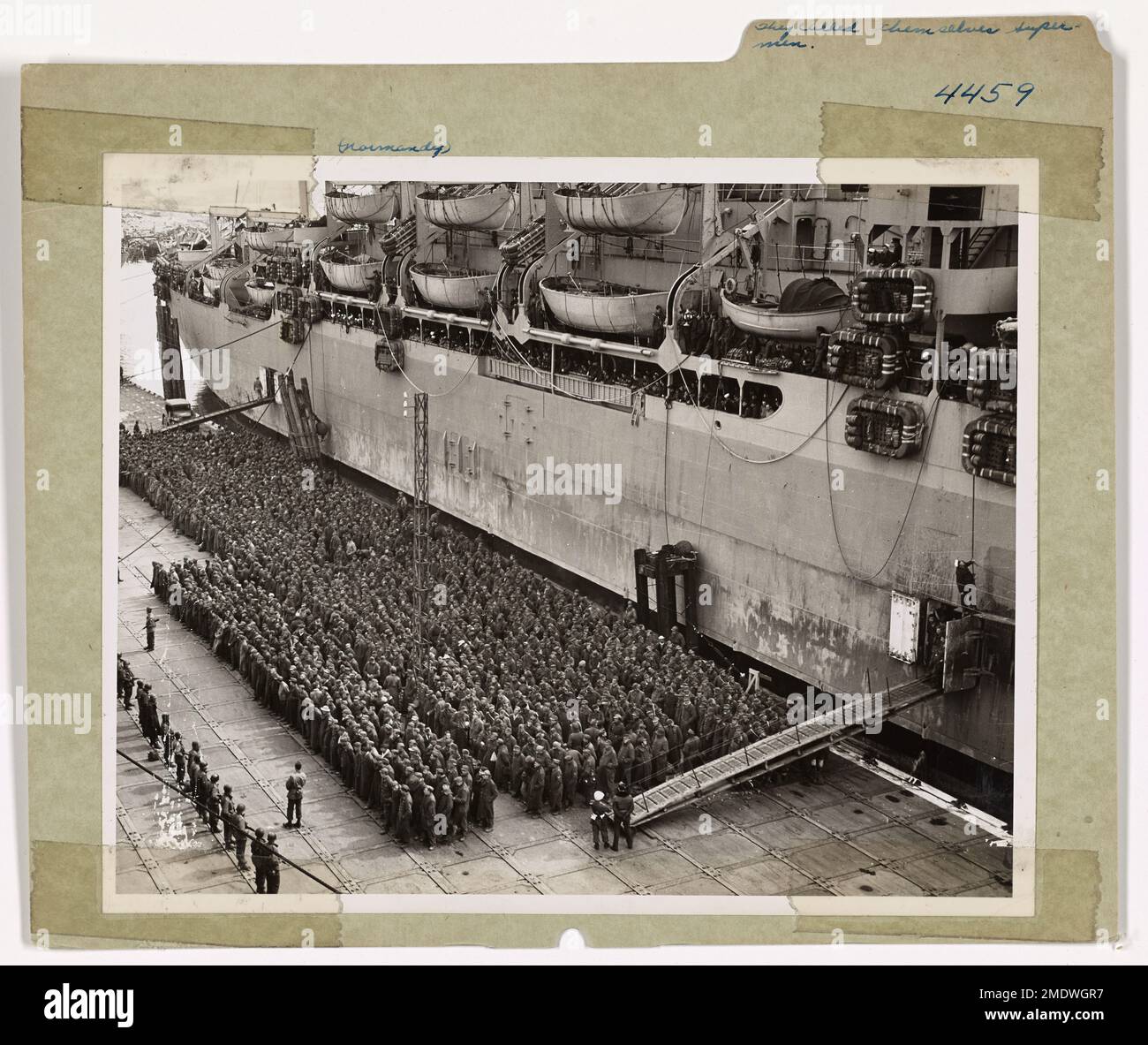 Ils se sont appelés « super ». Des milliers de soldats de la Wehrmacht, autrefois puissante, se tiennent sur les quais d'un port français pour l'embarquement à bord d'un transport de troupes de la Garde côtière vers les États-Unis. Ils ne représentent qu'une petite partie du flot de guerriers nazis qui trouvent un moyen de sortir de leur cause perdue en abandonnent les armées alliées qui traversent l'Allemagne. Banque D'Images