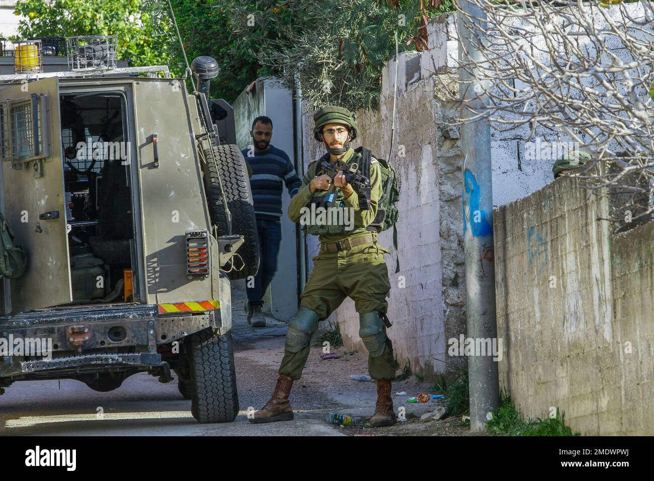 Naplouse, Palestine. 23rd janvier 2023. Les soldats israéliens se tiennent sur la garde tandis que d'autres soldats entourent et cherchent une maison, pendant le raid dans le village de Salem, à l'est de Naplouse, en Cisjordanie occupée. Les forces de l'armée israélienne se sont rompues dans le village de Salem et ont fouillé plusieurs maisons appartenant aux Palestiniens. Crédit : SOPA Images Limited/Alamy Live News Banque D'Images