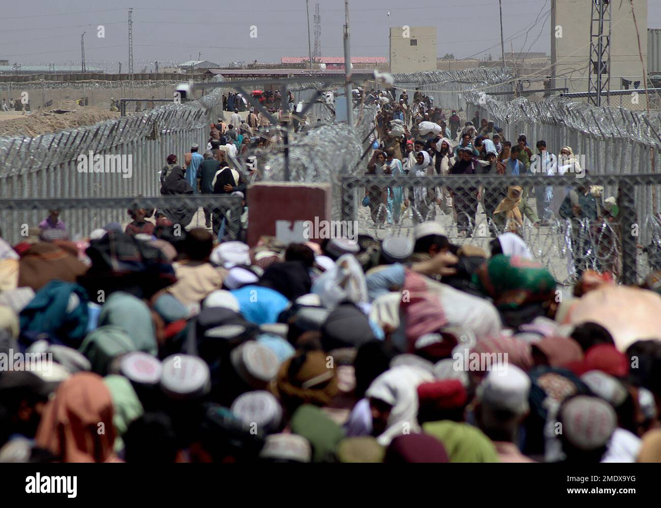 Stranded people crossing the border between Pakistan Afghanistan, in Chaman, Pakistan, Friday, Aug. 13, 2021. Pakistan opened its Chaman border crossing for people who had been stranded in recent weeks. Juma Khan, the Pakistan border town's deputy commissioner, said the crossing was reopened following talks with the Taliban. (AP Photo/Jafar Khan) Banque D'Images