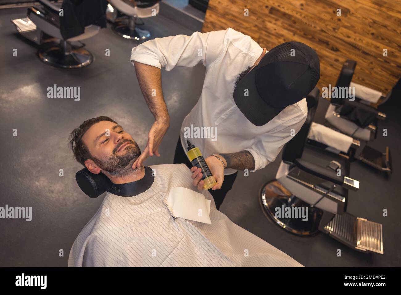 Coiffure appliquant hydratant sur le visage des clients Banque D'Images