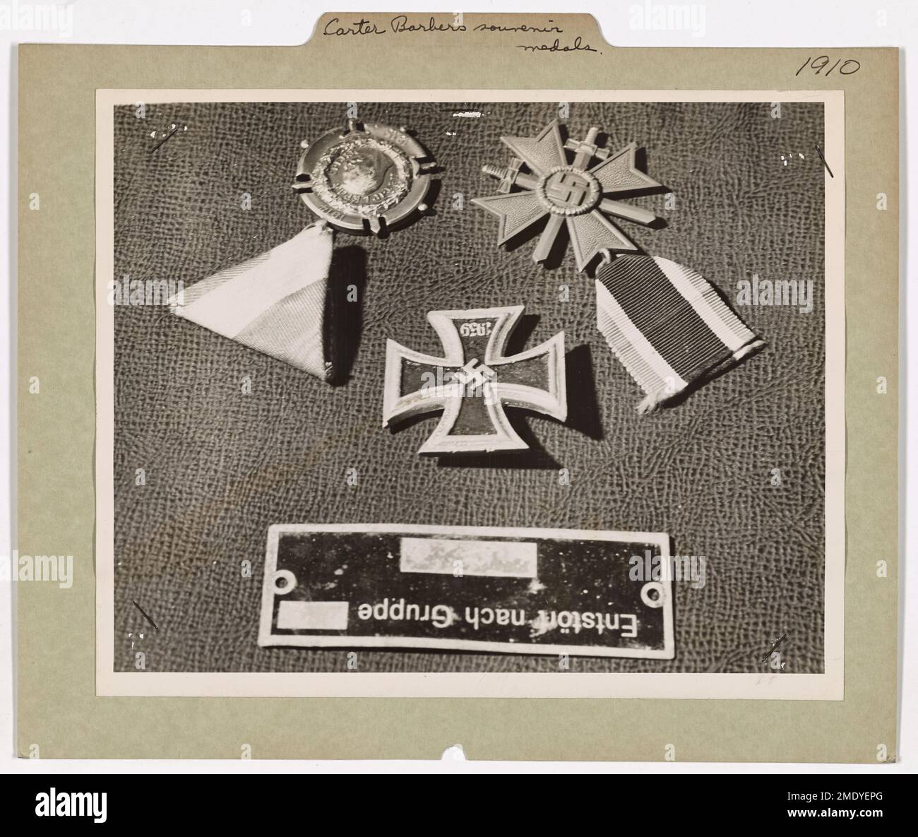 Le garde-côtes carter Barber, récemment revenu d'Afrique du Nord, expose des médailles et des souvenirs échangés par des prisonniers de l'axe, y compris une croix de fer allemande et une pièce d'avion naufragée. Banque D'Images
