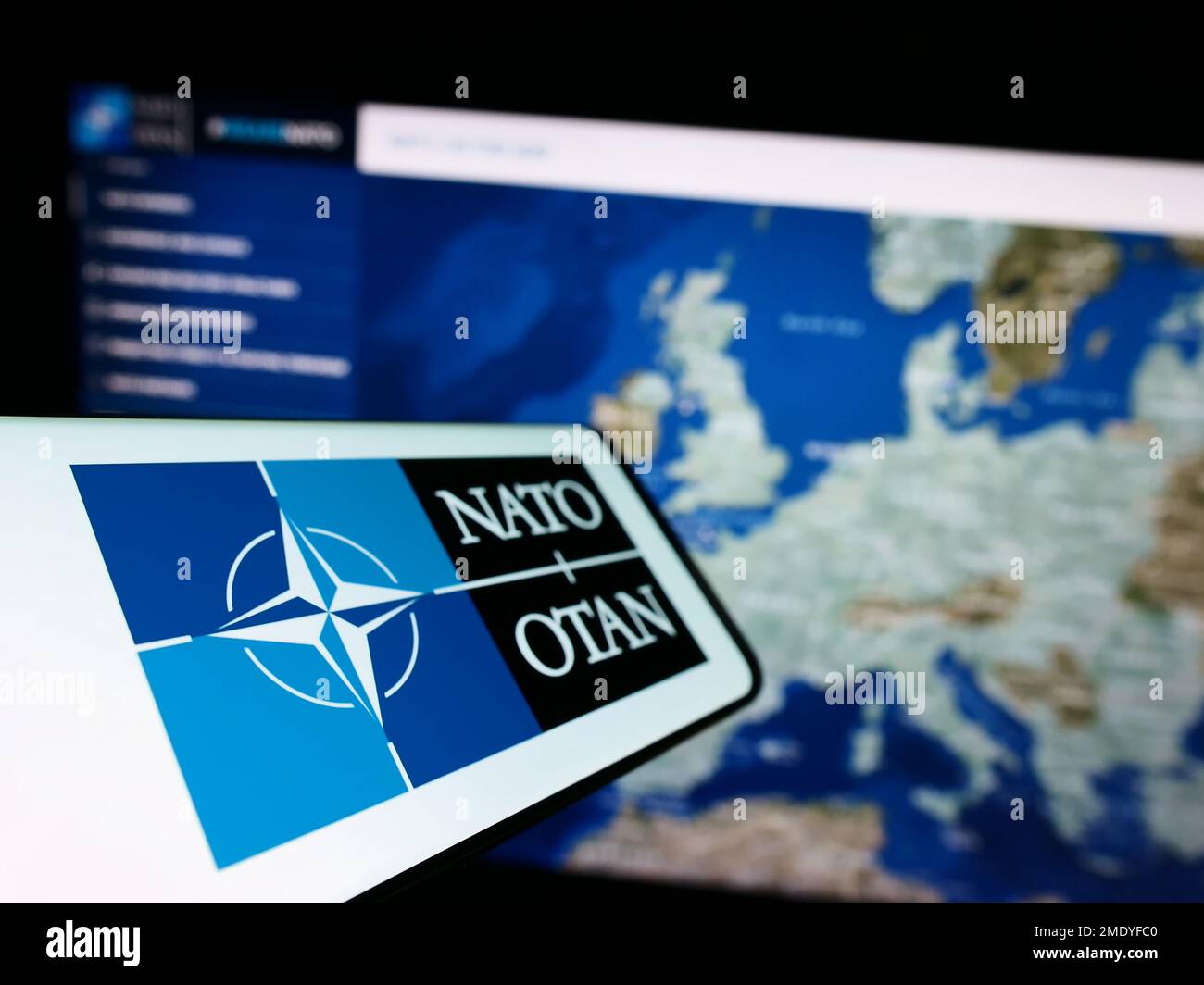 Smartphone avec logo de l'Organisation du Traité de l'Atlantique Nord (OTAN) sur écran devant le site Web. Mise au point à gauche de l'écran du téléphone. Banque D'Images