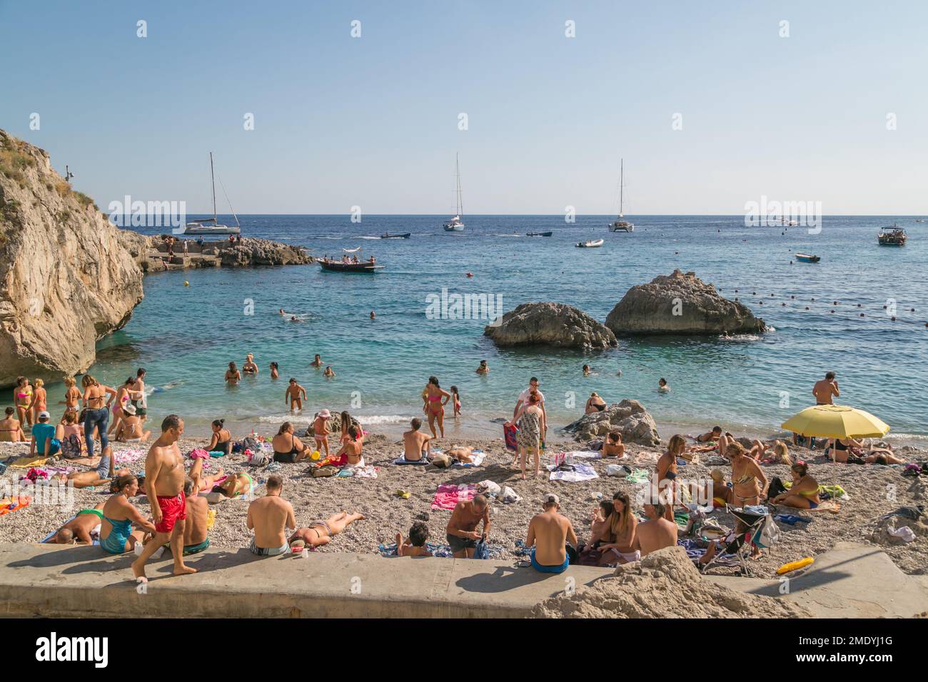 L'été, les gens nagent et se bronzent sur la plage de Capri, la baie de Naples, la mer Tyrrhénienne, Italie. Banque D'Images