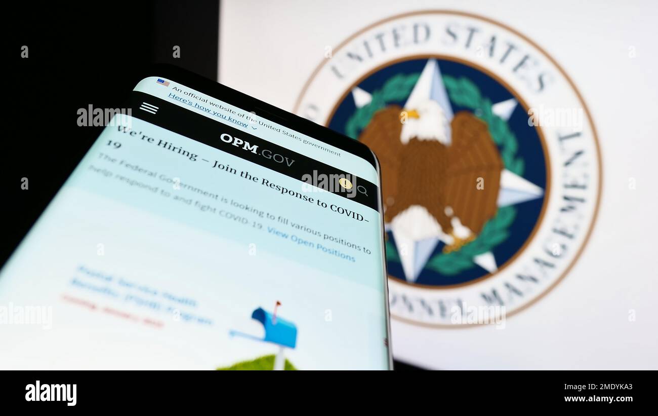 Smartphone avec le site Web de l'Office of personnel Management (OPM) des États-Unis sur l'écran devant le sceau. Faites la mise au point dans le coin supérieur gauche de l'écran du téléphone. Banque D'Images