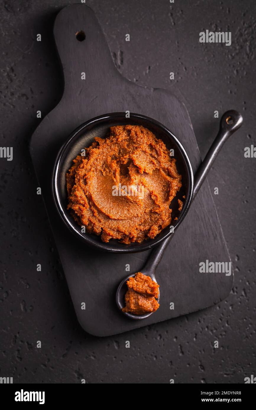 Pâte miso - aliments traditionnels japonais transformés à base de soja, sur fond noir Banque D'Images