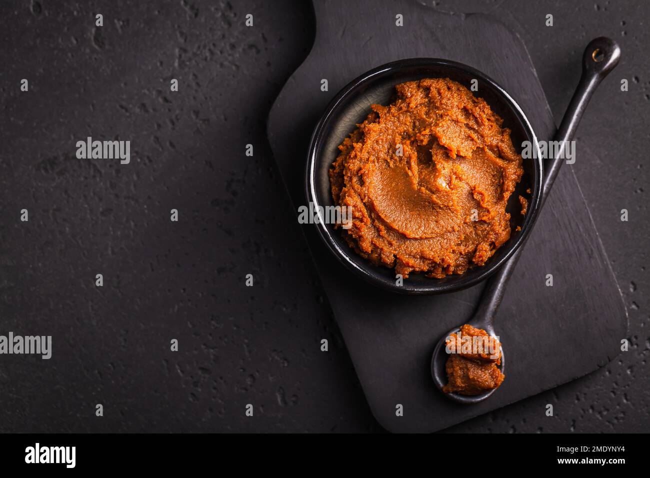 Pâte miso - aliments traditionnels japonais transformés à base de soja, sur fond noir Banque D'Images