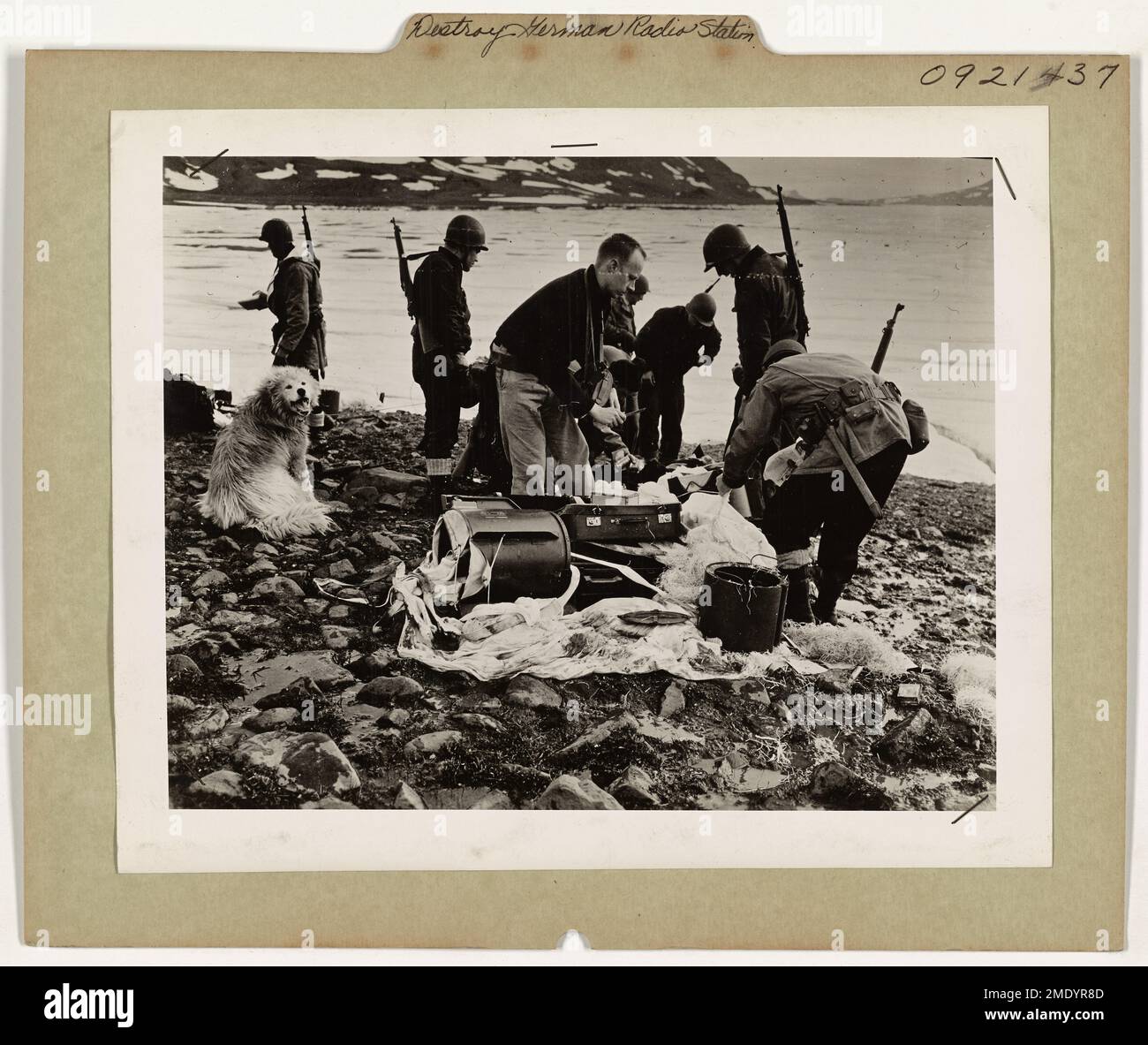 Détruire la base radio allemande au Groenland. Membres de l'ensemble des États-Unis La Garde côtière et le groupe de travail de l'Armée examinent une trousse de parachute nazi abandonnée qui se trouve sur le site de la base radio de l'Armée allemande. La nourriture, les grenades à main et d'autres matériaux ont été abandonnés par les Nazis à la suite de l'attaque sur la base par une armée de l'air américaine. Les Allemands ont probablement été évacués par avion. Banque D'Images