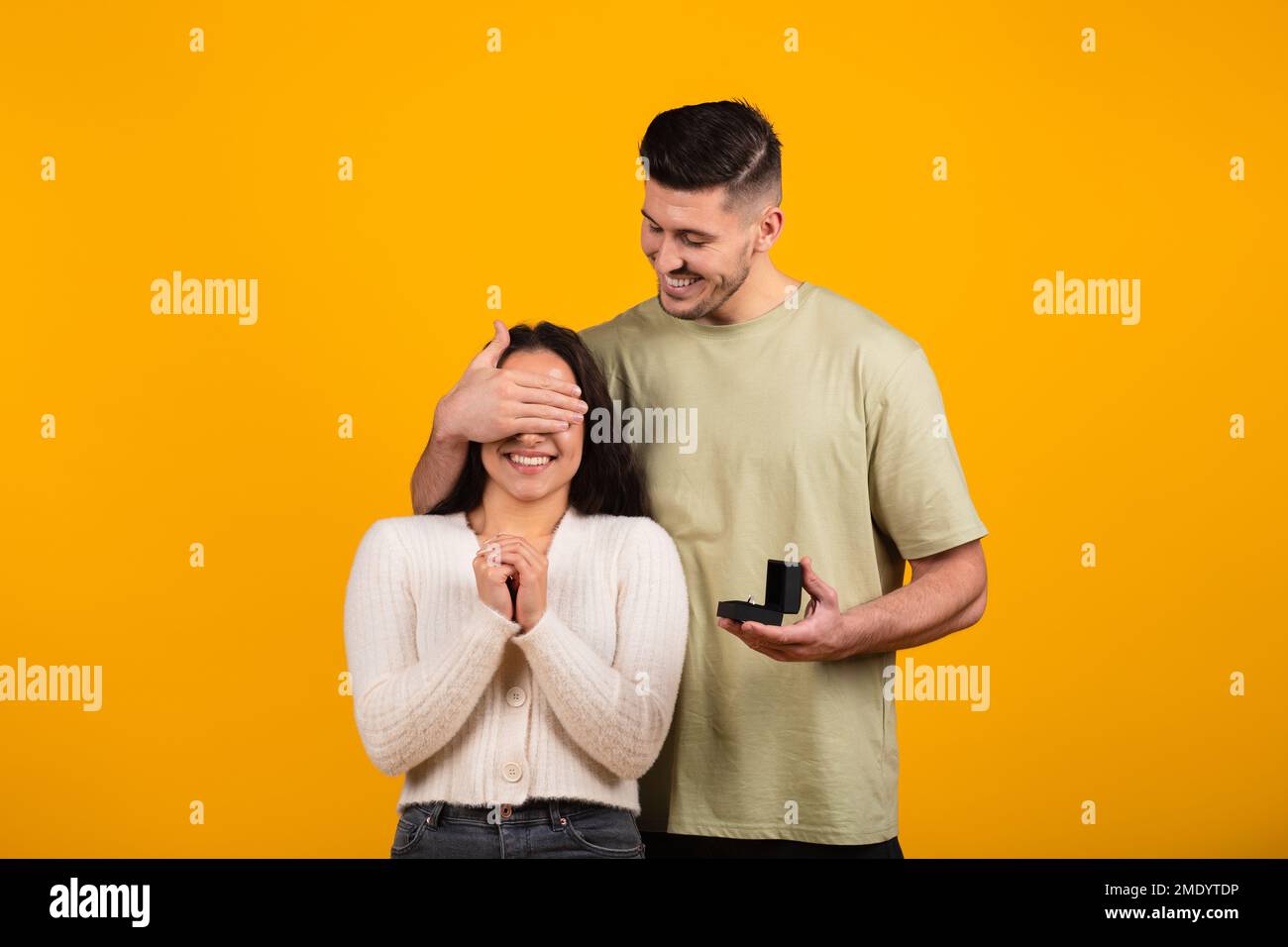 Joyeux millennium grand homme arabe proche des yeux à la femme stupéfait, tenir boîte avec anneau Banque D'Images
