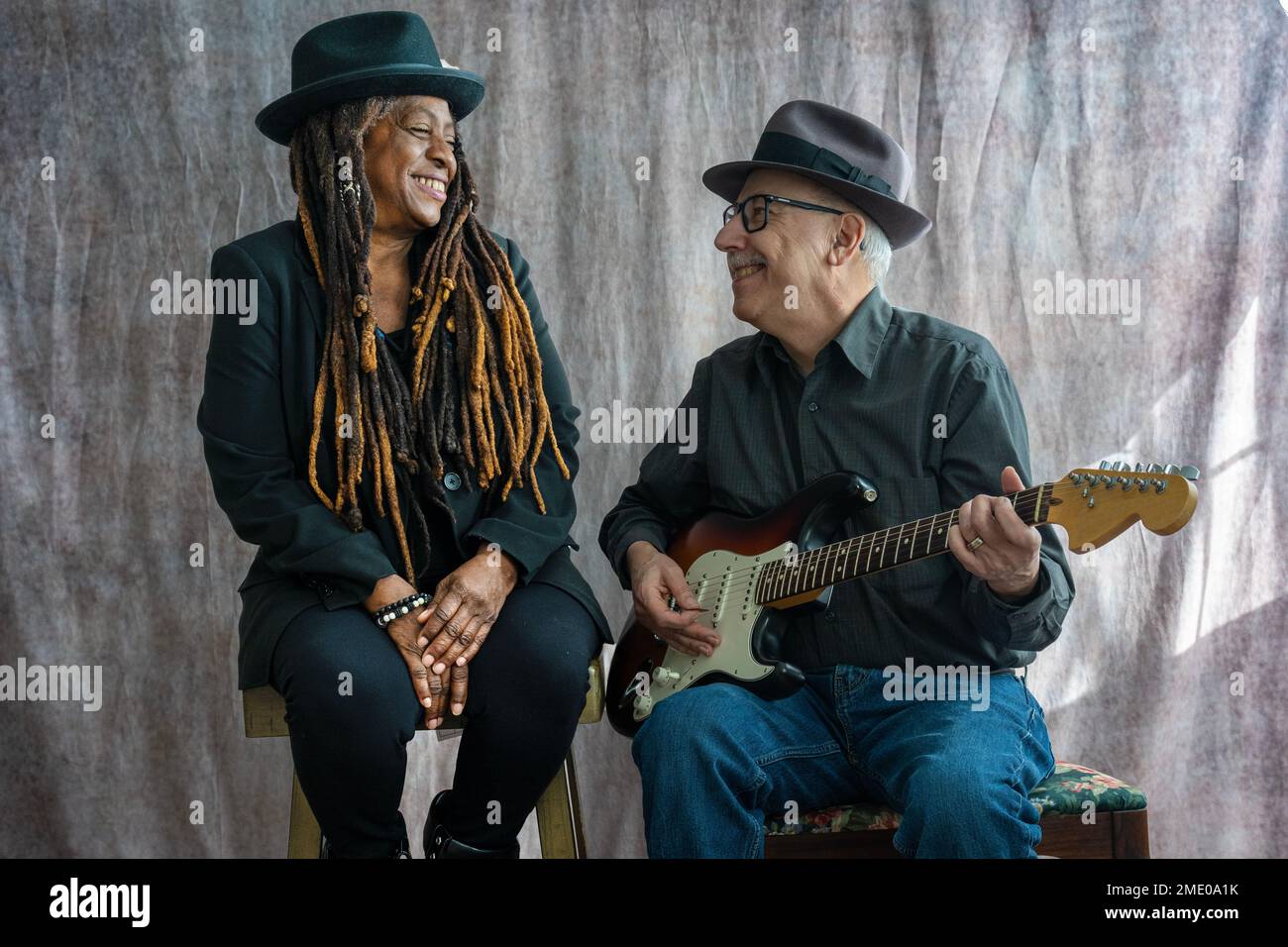 Femme afro-américaine senior et homme blanc senior chantant et jouant à la guitare Banque D'Images