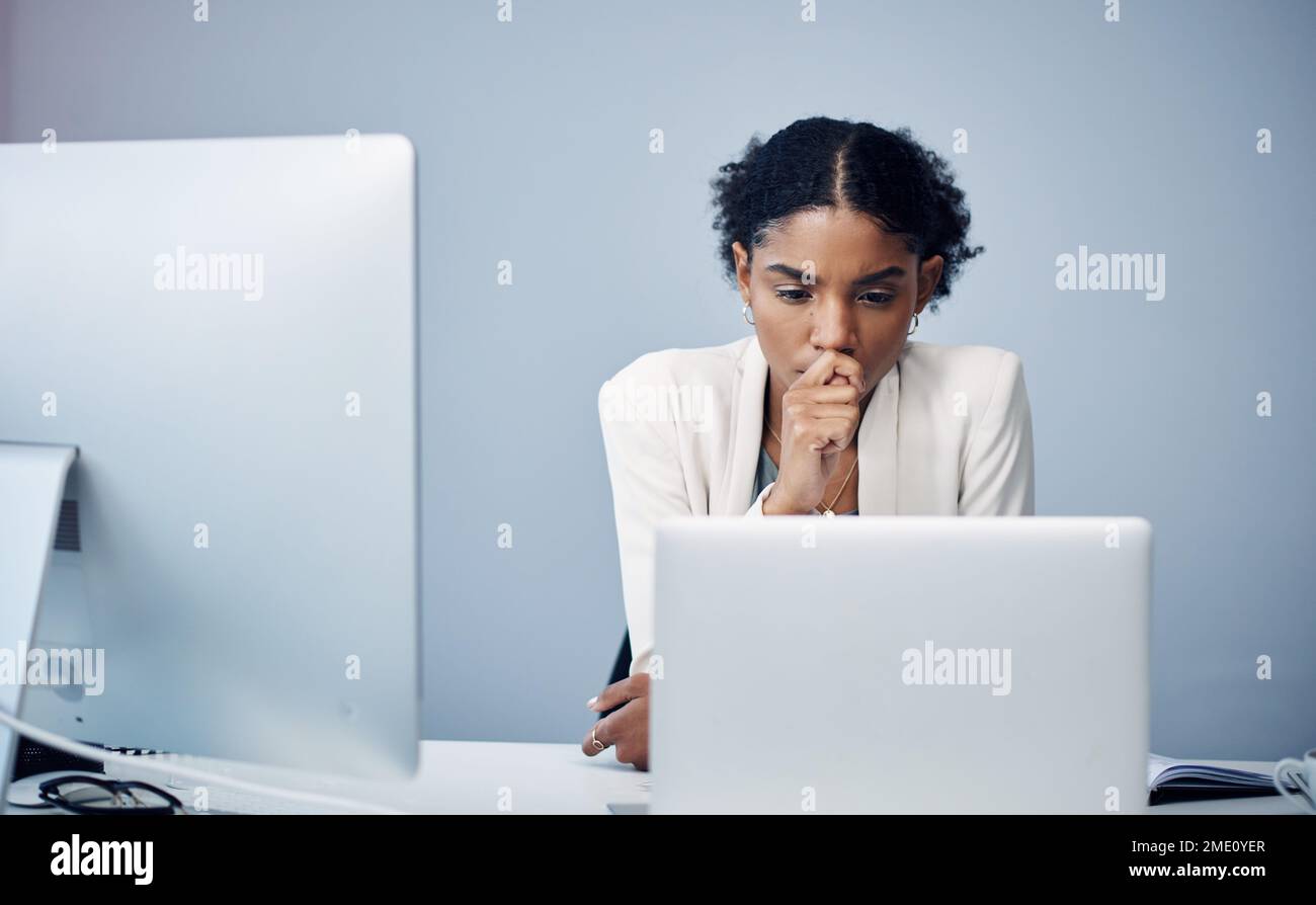 Comment puis-je en parler à mon patron. une jeune femme d'affaires utilisant un ordinateur portable et regardant son bureau dans un bureau moderne. Banque D'Images