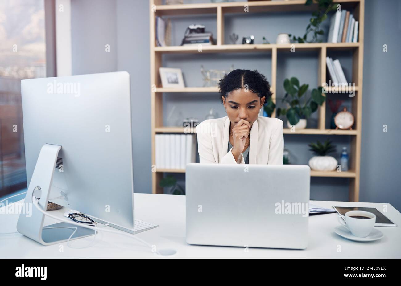 Est mon travail sur la ligne. une jeune femme d'affaires utilisant un ordinateur portable et regardant son bureau dans un bureau moderne. Banque D'Images
