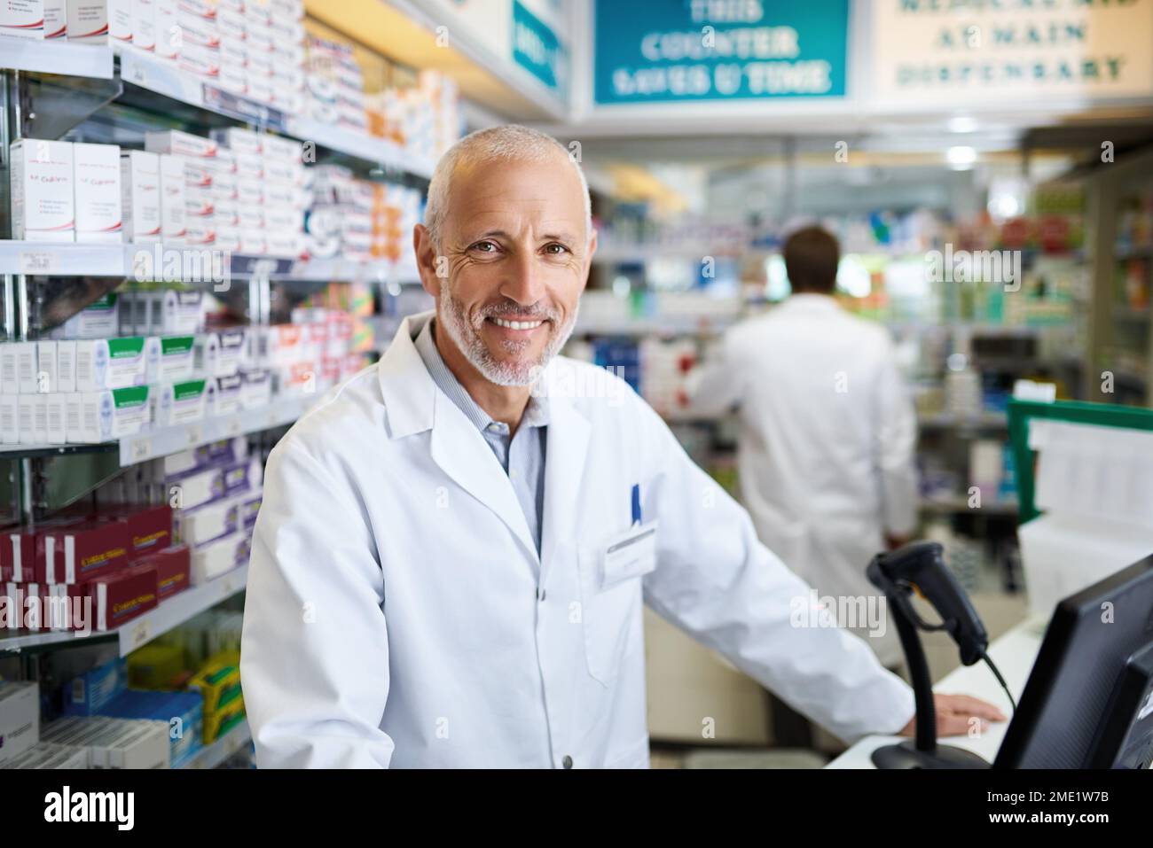 Pas besoin d'acheter ailleurs car nos stocks sont toujours pleins. Portrait d'un pharmacien mature travaillant sur un ordinateur dans un chimiste. Banque D'Images