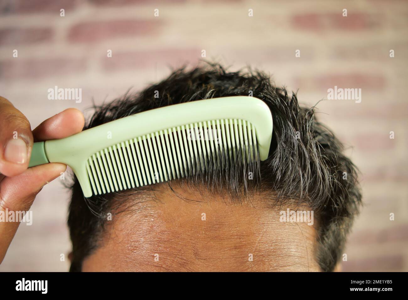 homme coiffant les cheveux avec le sabot en gros plan Banque D'Images