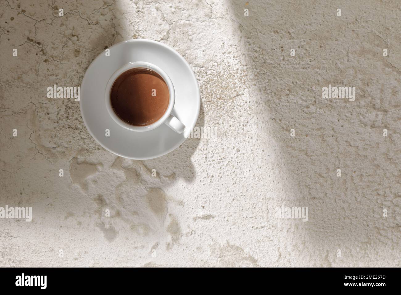 Boisson au cacao dans une tasse blanche sur fond blanc d'argile texturée, vue du dessus Banque D'Images