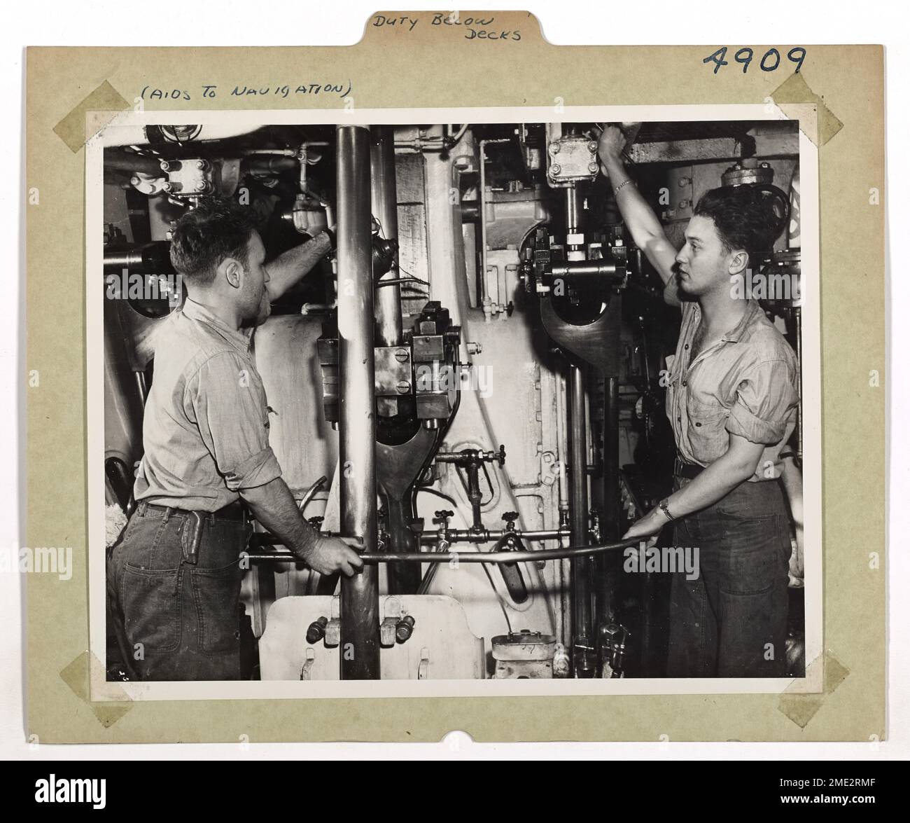 Les membres de l'équipage à bord du Lightship No 107, 'Winter Quarter', appliquent de l'huile sur le guide transversal du moteur principal. Le moteur est essentiel pour maintenir la position du phare pendant les tempêtes afin de s'assurer que sa balise continue de fonctionner et de guider les navires en toute sécurité. Banque D'Images