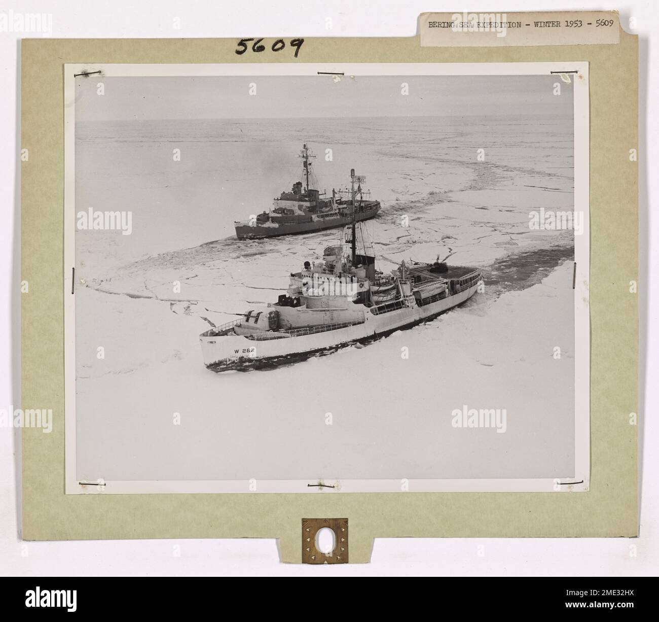 Deux brise-glaces utilisent une méthode tandem pour briser la glace dans la mer de Béring. Les navires alternent percussion et recul pour dégager un chemin à travers la glace épaisse, ce qui fait partie d'une mission critique dans les eaux polaires. Banque D'Images
