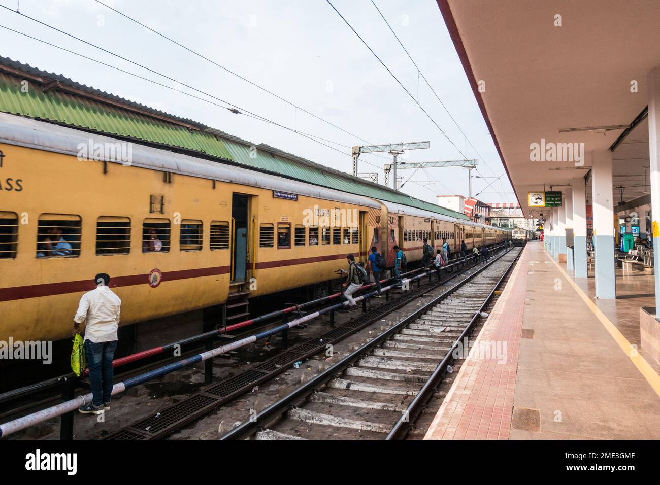 Les gens qui traversent les rails dangereusement pour entrer dans les trains au bengaluru cantment stationv Banque D'Images