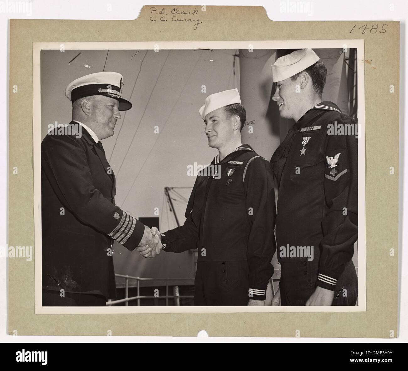 Le capitaine C. W. Harwood félicite le garde-côtes P. L. Clark et son compagnon de pharmacien C. C. Curry pour leur bravoure durant la campagne nord-africaine. Clark a reçu la Navy Cross pour avoir évacué les blessés sous le feu, tandis que Curry a reçu la Silver Star pour avoir fourni une aide médicale pendant les opérations de combat. Banque D'Images
