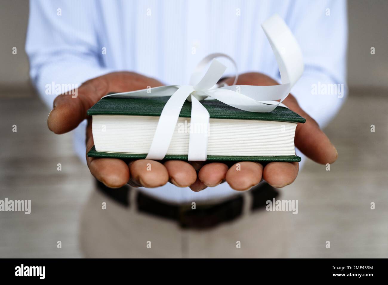 Mains de l'homme tenant le livre attaché avec le ruban blanc Photo Stock -  Alamy