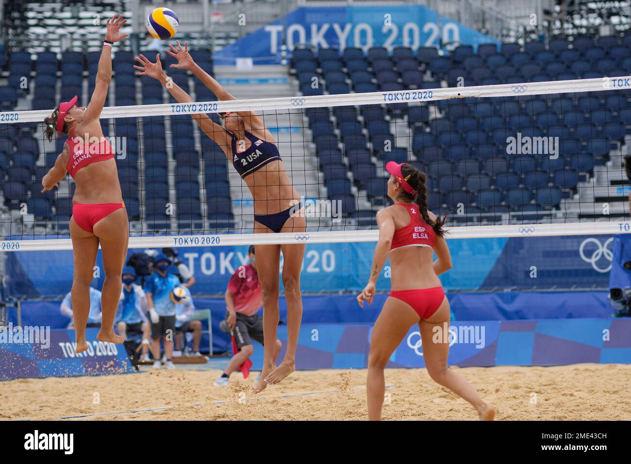 April Ross, center, of the United States, tries to block the shot of Liliana Fernandez Steiner, left, of Spain, as teammate Elsa Baquerizo McMillan, watches during a women's beach volleyball match at the 2020 Summer Olympics, Tuesday, July 27, 2021, in Tokyo, Japan. (AP Photo/Petros Giannakouris) Banque D'Images