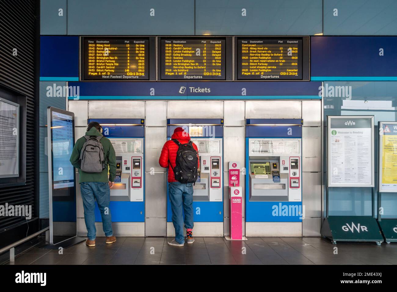 Les gens achètent des billets de chemin de fer aux distributeurs de billets en libre-service de la gare de Reading. Les écrans électroniques fournissent des informations sur les départs à venir. Banque D'Images