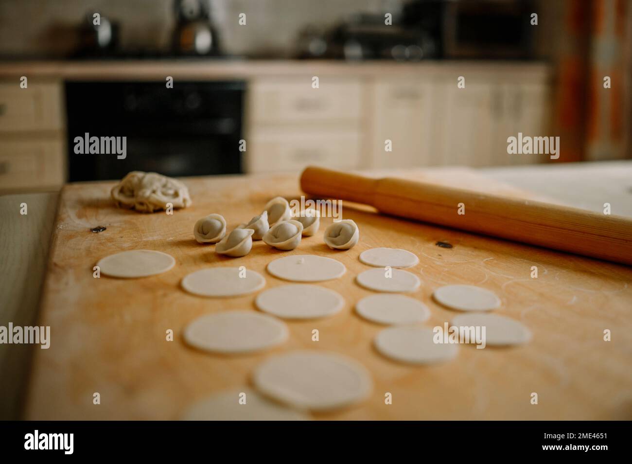 Rolling PIN par des boulettes sur la planche à découper dans la cuisine à la maison Banque D'Images