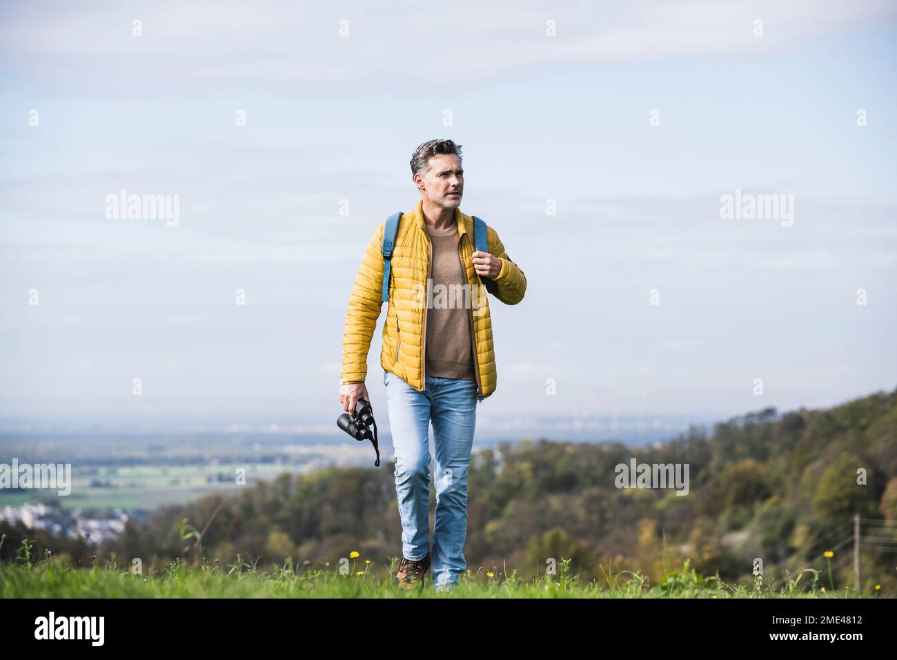 Homme mature avec sac à dos et jumelles randonnée en vacances Banque D'Images
