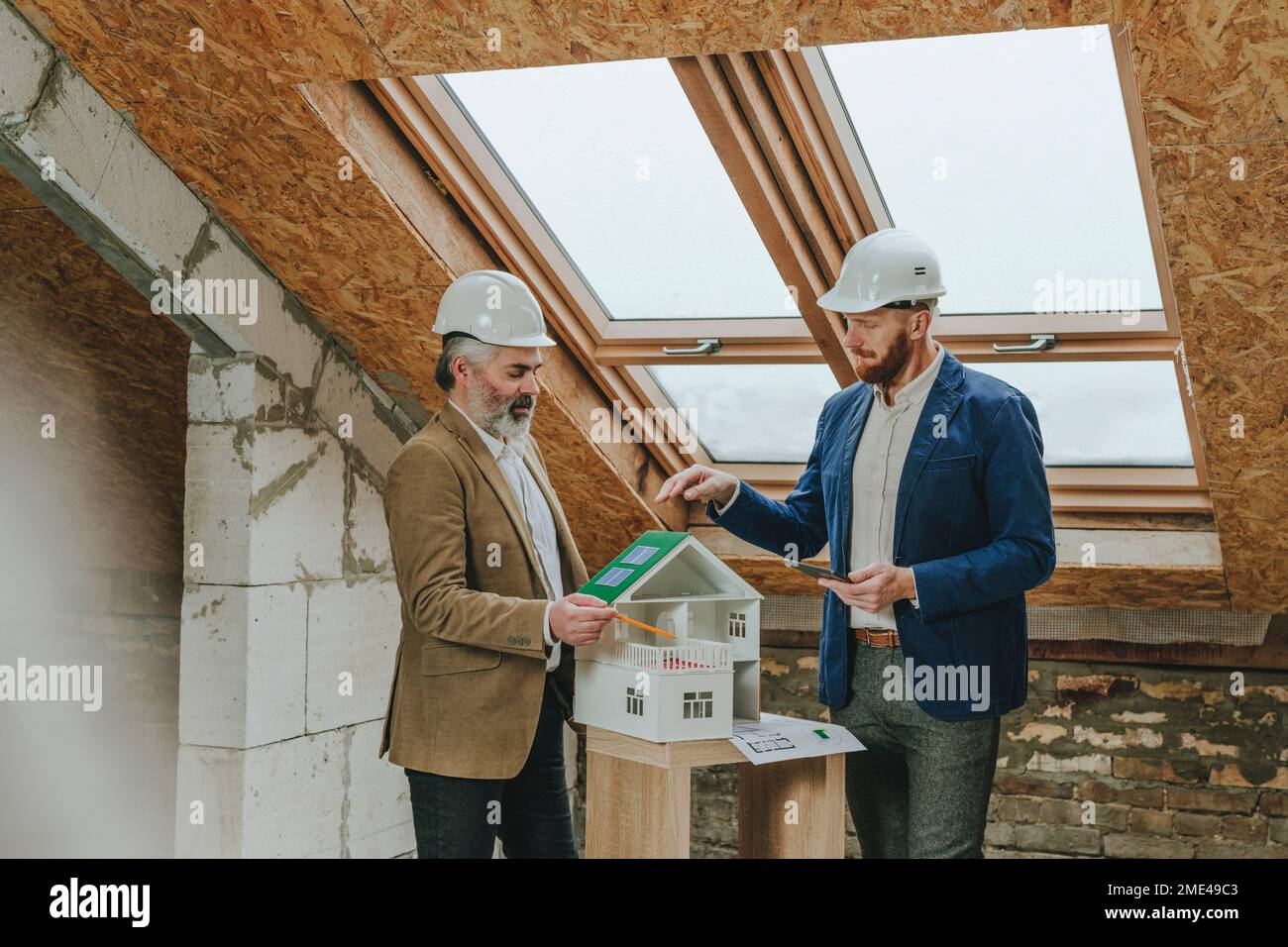 Architecte expliquant à ses collègues la maison modèle sur le chantier de construction Banque D'Images